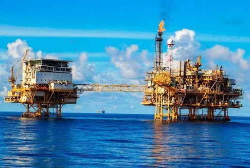 Plataformas petrolíferas no mar, ligadas por uma passagem elevada.