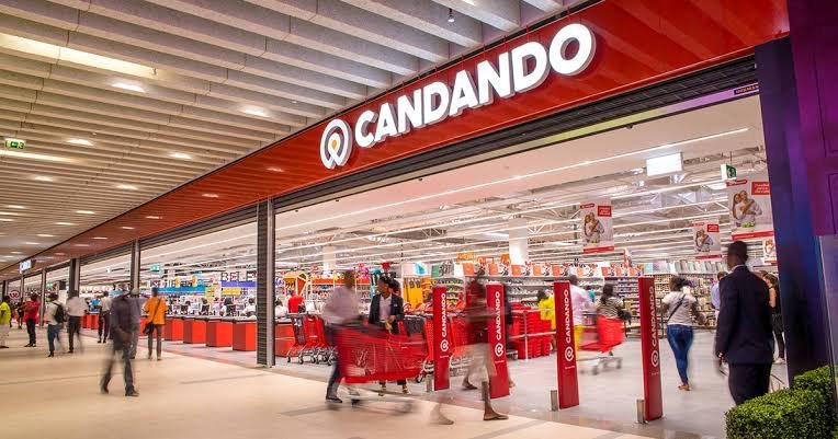 Entrada de uma loja Candando, com letreiro vermelho e carrinhos de compras.