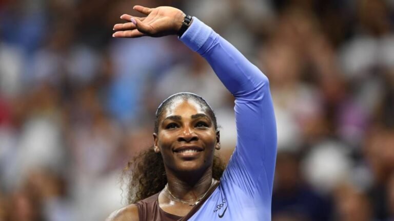 Tenista Serena Williams com o braço levantado em campo.