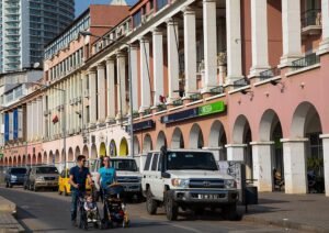Rua de Luanda com edifícios, veículos e peões.