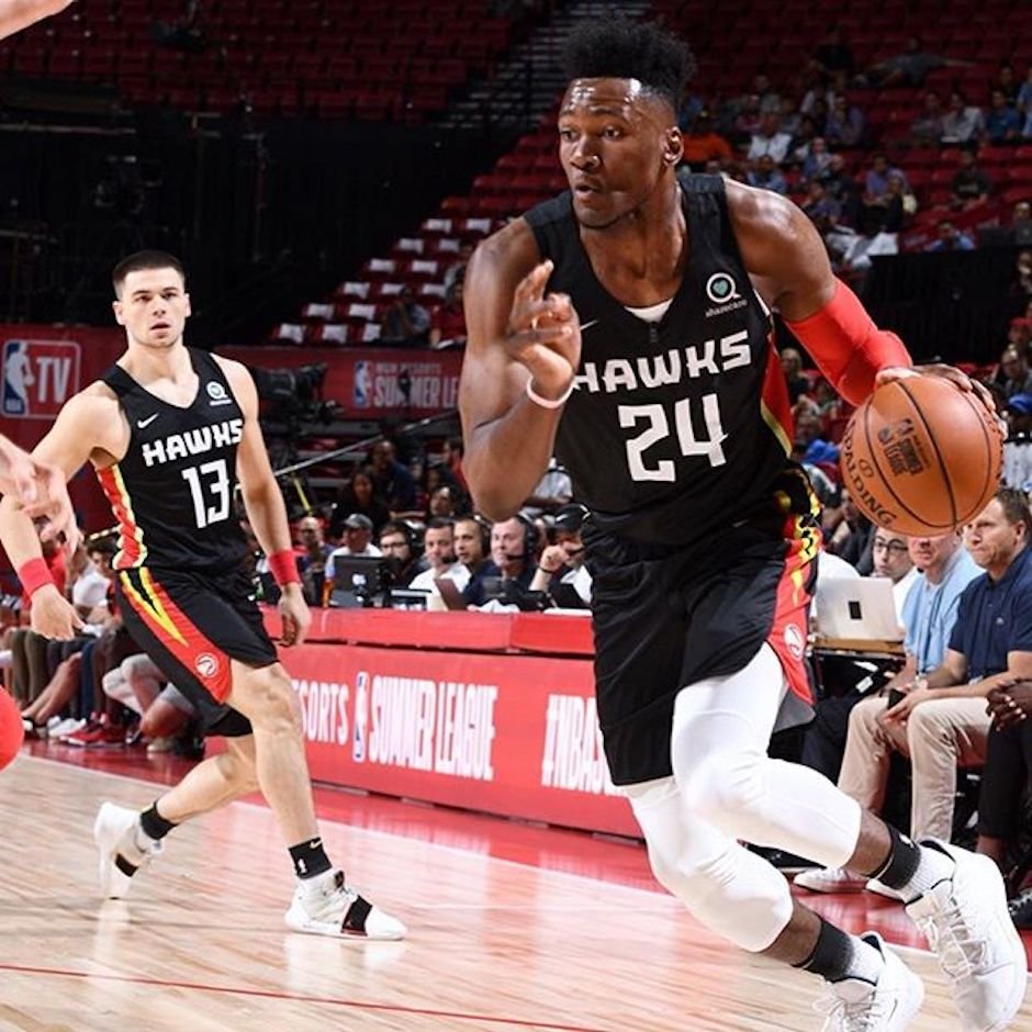 Jogador dos Atlanta Hawks com o número 24 conduz a bola durante um jogo.